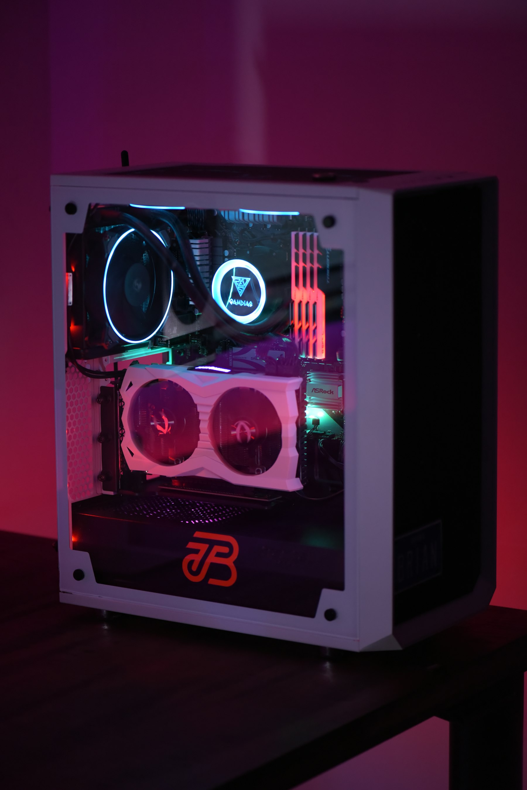 Compact white PC tower with colorful internal lighting on a dark desk